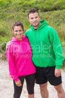 Athletic couple looking at camera and embracing