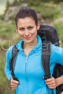 Smiling female hiker with backpack looking at camera
