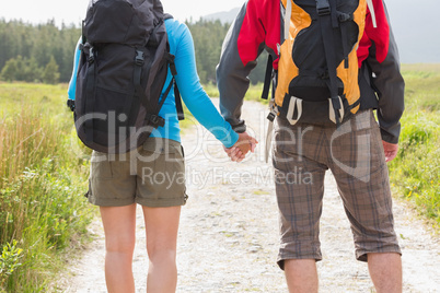 Hikers with backpacks holding hands