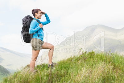 Pretty hiker with backpack walking uphill