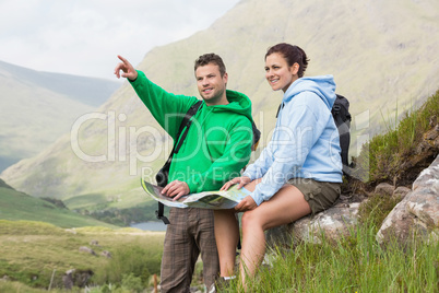 Couple resting after hiking uphill and consulting map
