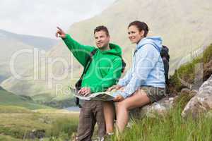 Couple resting after hiking uphill and consulting map