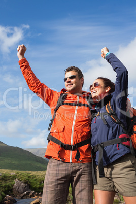 Couple on a hike cheering and smiling