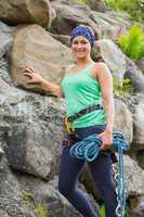 Attractive female rock climber smiling at camera