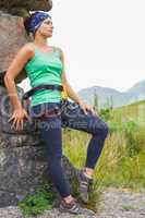 Attractive female rock climber leaning on rock face