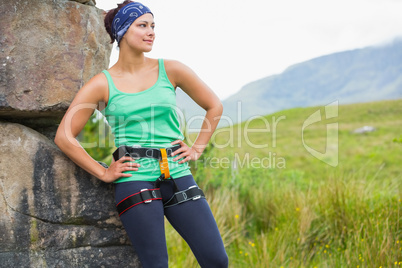 Pretty female rock climber leaning on rock face