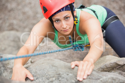 Focused girl climbing rock face