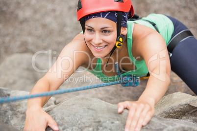 Happy girl climbing rock face