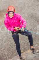 Happy girl abseiling down rock face
