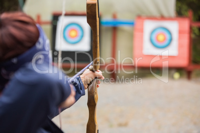 Brunette about to shoot arrow