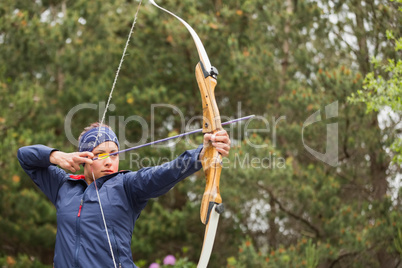 Concentrating brunette practicing archery