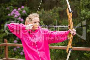 Concentrating blonde practicing archery