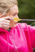 Focused blonde practicing archery