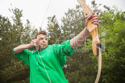 Concentrating man practicing archery