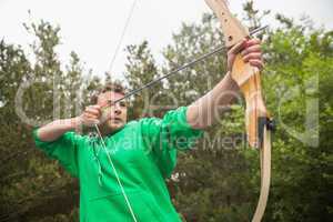 Concentrating man practicing archery