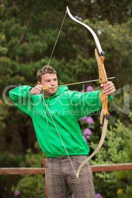Focused man practicing archery