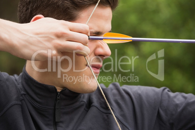 Concentrated man practicing archery