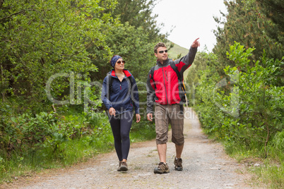 Couple going on a hike together with man pointing
