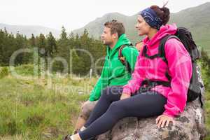 Couple sitting on a rock admiring the scenic view