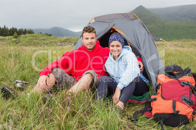 Couple on camping trip smiling at camera