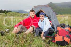 Couple on camping trip smiling at camera