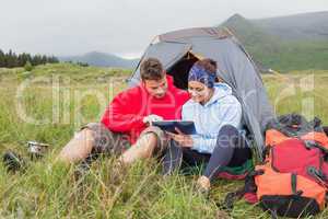 Couple on camping trip using a digital tablet