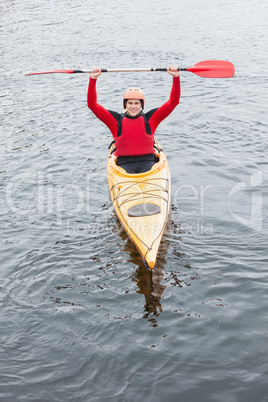 Happy man in a kayak cheering at camera