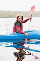 Happy woman rowing on lake