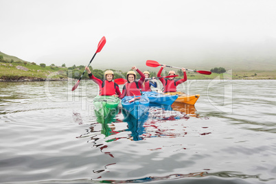 Fit friends rowing on a lake