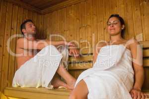 Happy couple relaxing in a sauna