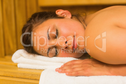 Smiling brunette lying down in a sauna
