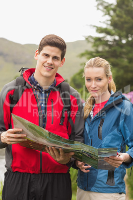 Happy couple holding map on a hike Happy couple holding map on a hike