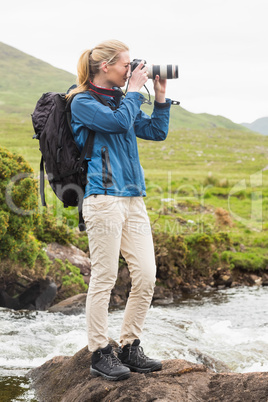 Blonde woman on a hike taking a photo