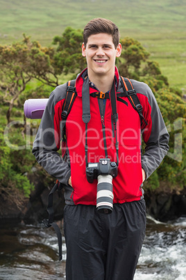 Handsome man on a hike with camera around his neck