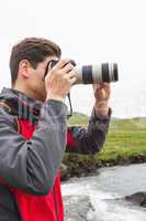 Brunette man on a hike taking a photograph