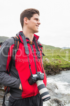 Brunette man on a hike with a camera around his neck