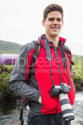 Happy man on a hike with a camera around his neck