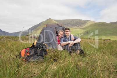 Couple sitting in their tent after a hike