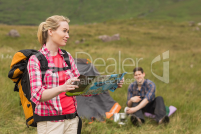 Smiling woman carrying backpack and holding map