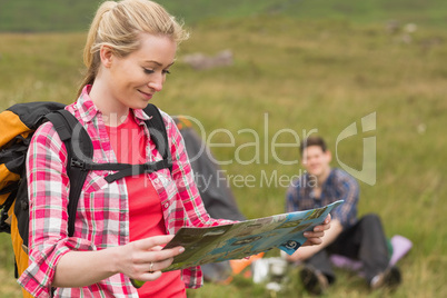 Happy woman carrying backpack and holding map