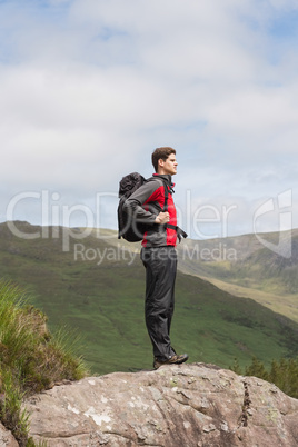 Handsome man standing at hill top admiring the view