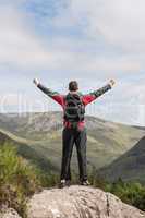 Man standing at hill top cheering
