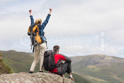 Excited couple reaching the top of their hike