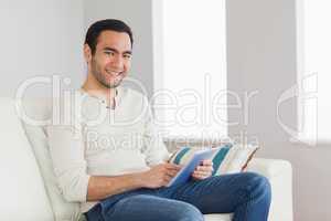 Cheerful casual man using his tablet