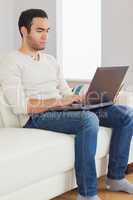 Focused handsome man using his tablet computer