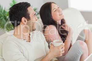 Cheerful couple relaxing together on sofa