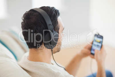 Handsome man listening to music on his smartphone