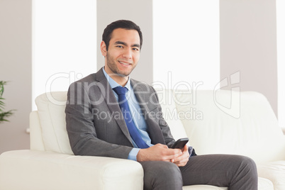 Smiling businessman sitting on cosy sofa