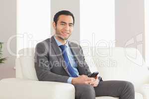 Smiling businessman sitting on cosy sofa