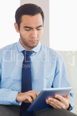 Young classy businessman using tablet pc